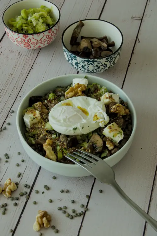 Bol de salade tiède de lentilles vertes avec chèvre frais, poireaux et champignons