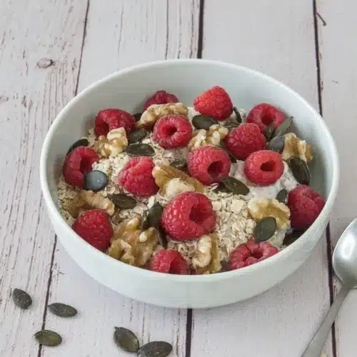 Petit-déjeuner au skyr, avoine et framboises IG bas Bol de skyr avec flocons d'avoine, framboises fraîches, noix et graines de courge.