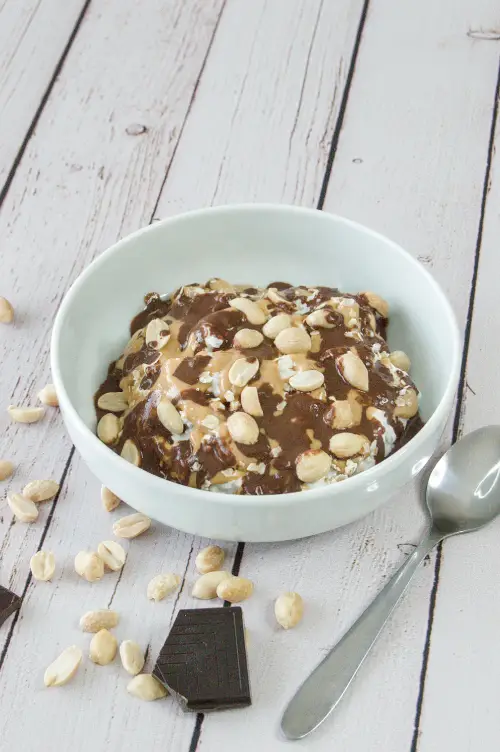 Petit-déjeuner au skyr, chocolat noir et cacahuète IG bas Bol d'un petit-déjeuner au skyr au chocolat noir fondu, beurre de cacahuète et cacahuètes nature pour un petit-déjeuner équilibré