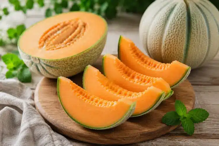 Peut-on manger du melon quand on est diabétique ? Quartiers de melon frais sur une planche en bois illustrant les bienfaits du melon dans une alimentation adaptée au diabète.